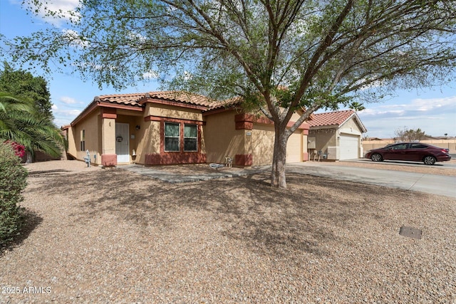 view of front of property with driveway, a tiled roof, a garage, and stucco siding