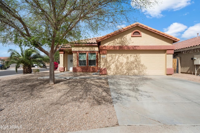 ranch-style home featuring driveway, a tiled roof, an attached garage, and stucco siding