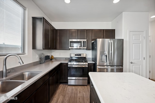 kitchen featuring dark brown cabinets, stainless steel appliances, sink, and hardwood / wood-style floors