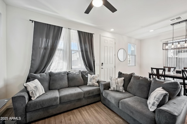 living room featuring light hardwood / wood-style flooring and ceiling fan