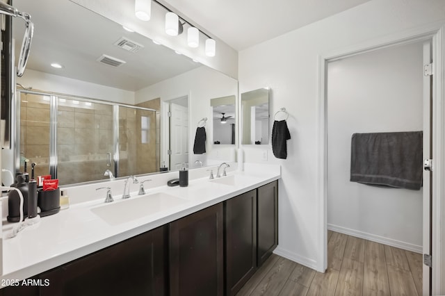 bathroom featuring ceiling fan, vanity, a shower with shower door, and hardwood / wood-style floors