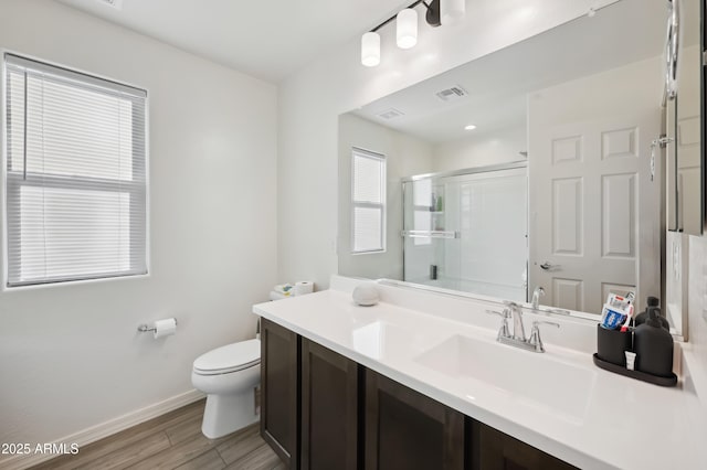 bathroom with vanity, hardwood / wood-style floors, an enclosed shower, and toilet