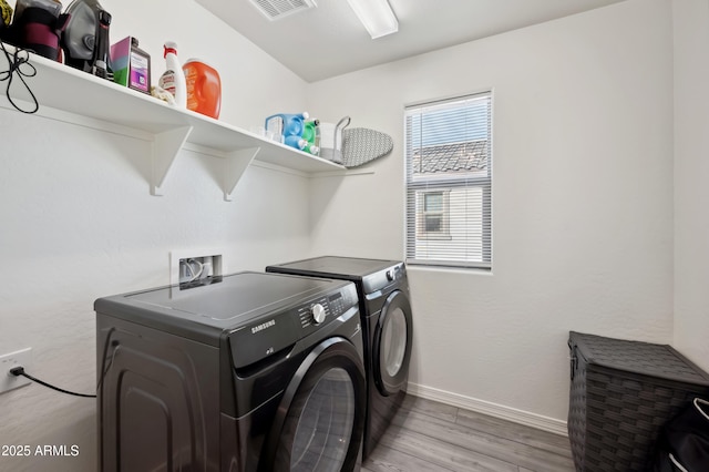 washroom featuring hardwood / wood-style flooring and washing machine and dryer