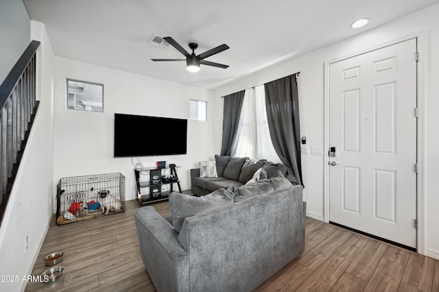 living room featuring wood-type flooring and ceiling fan