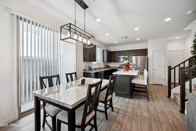 dining room with sink and light hardwood / wood-style floors