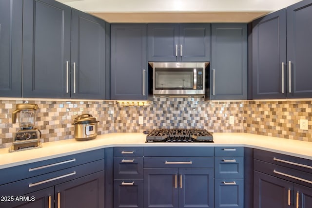 3298 W Monte Vista Trl, Benson, AZ 85602 - kitchen featuring blue cabinets, stainless steel microwave, backsplash, and light countertops