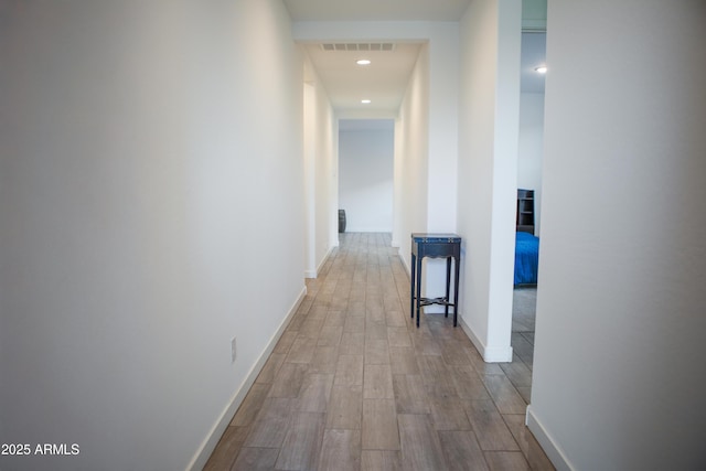 hall with recessed lighting, light wood-type flooring, visible vents, and baseboards