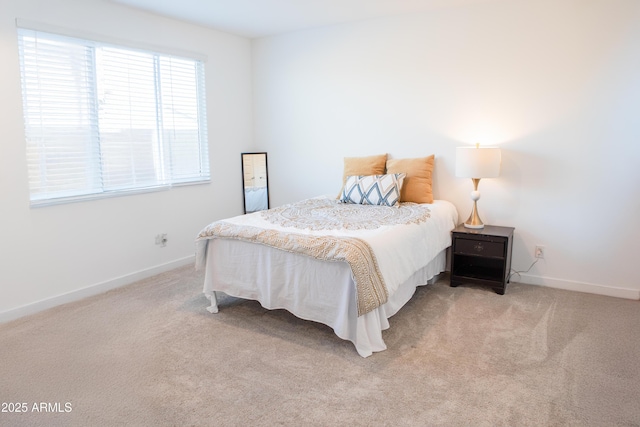 bedroom featuring light carpet and baseboards