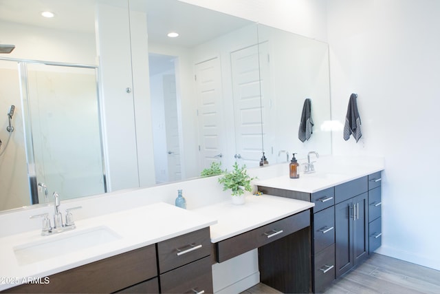 bathroom featuring vanity, wood-type flooring, and a shower with shower door