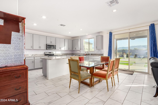 kitchen featuring a mountain view, appliances with stainless steel finishes, a center island, and gray cabinets