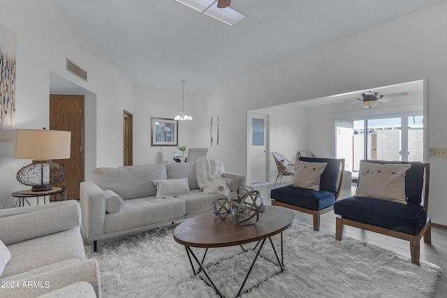 living room featuring ceiling fan with notable chandelier