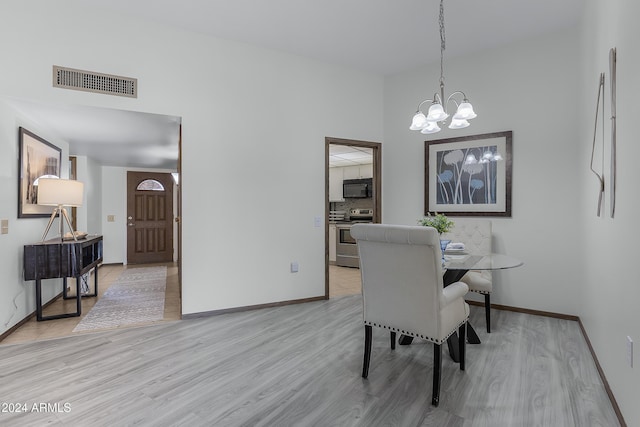 dining space featuring light hardwood / wood-style flooring and a chandelier