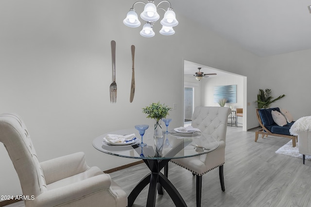 dining space with light hardwood / wood-style floors and ceiling fan with notable chandelier