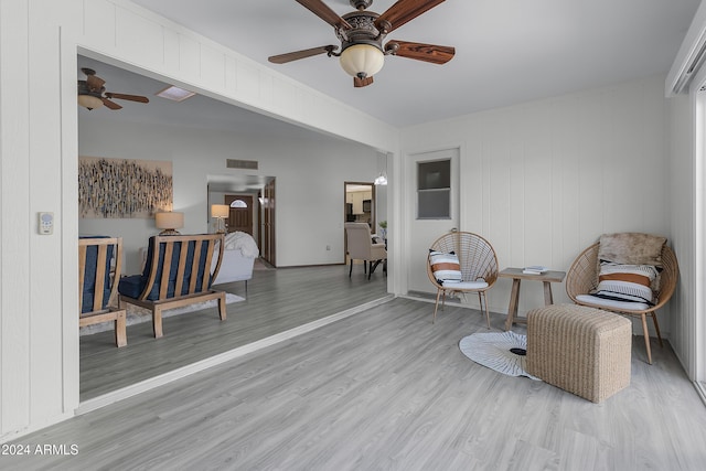 living area with ceiling fan and light hardwood / wood-style floors