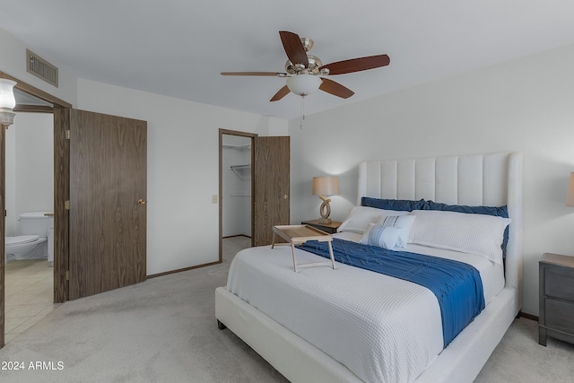 carpeted bedroom featuring ceiling fan, a closet, and ensuite bathroom