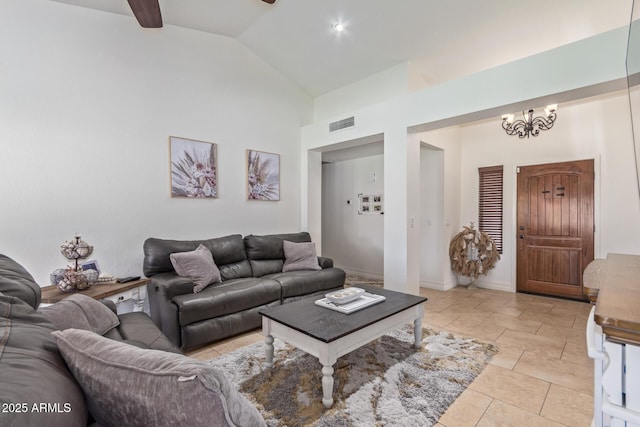 living room with visible vents, baseboards, lofted ceiling, ceiling fan with notable chandelier, and light tile patterned floors