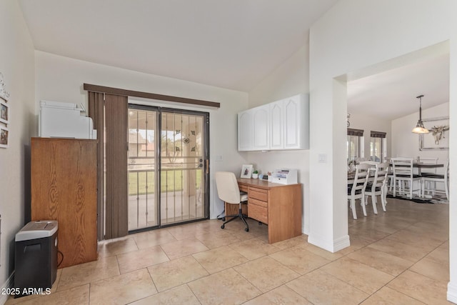 home office with built in study area, light tile patterned floors, and lofted ceiling