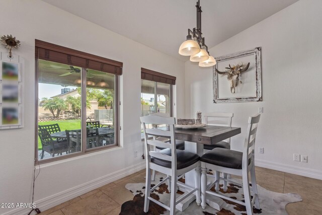 tiled dining room with baseboards and vaulted ceiling