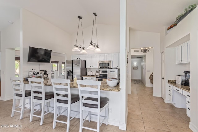 kitchen featuring white cabinetry, a kitchen breakfast bar, stainless steel appliances, and a peninsula