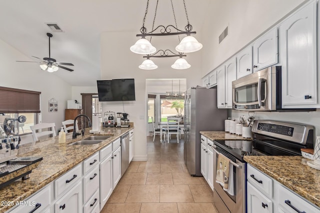 kitchen with visible vents, light stone countertops, stainless steel appliances, white cabinetry, and a sink