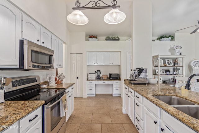 kitchen featuring white cabinets, a sink, stainless steel appliances, and light stone counters