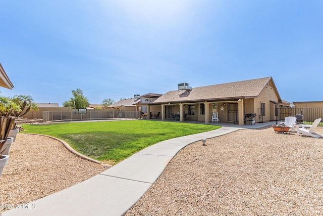 rear view of property featuring an outdoor fire pit, a fenced backyard, stucco siding, a lawn, and a patio area