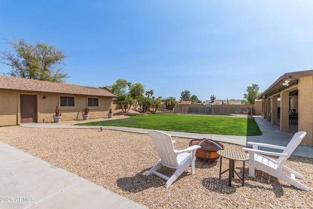 view of yard with a fire pit, a fenced backyard, and a patio area