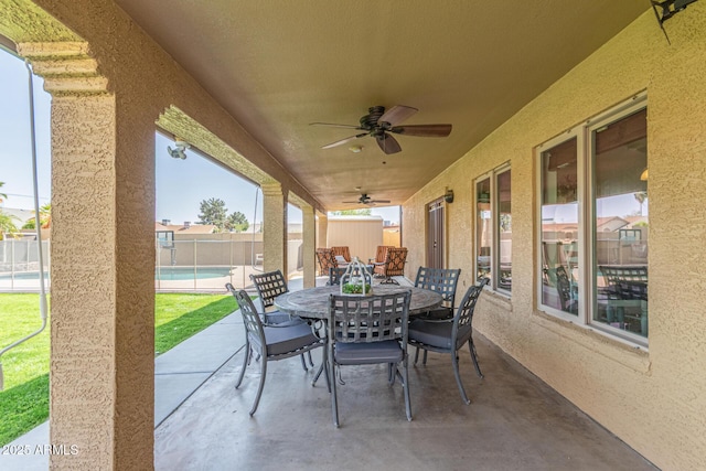 view of patio with a ceiling fan, outdoor dining area, fence, and a fenced in pool