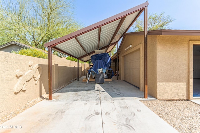 view of parking / parking lot featuring a garage, fence, and concrete driveway