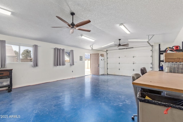 garage featuring baseboards, freestanding refrigerator, a wood stove, and a ceiling fan
