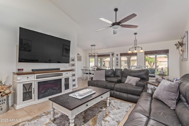 living area with a healthy amount of sunlight, lofted ceiling, light tile patterned floors, and a ceiling fan