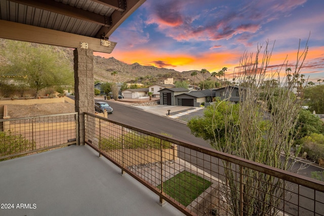 balcony at dusk featuring a mountain view