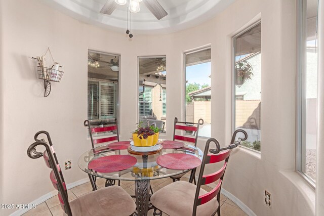 dining space featuring ceiling fan, baseboards, and tile patterned flooring