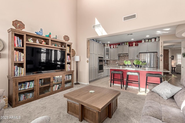 living room featuring a high ceiling and visible vents