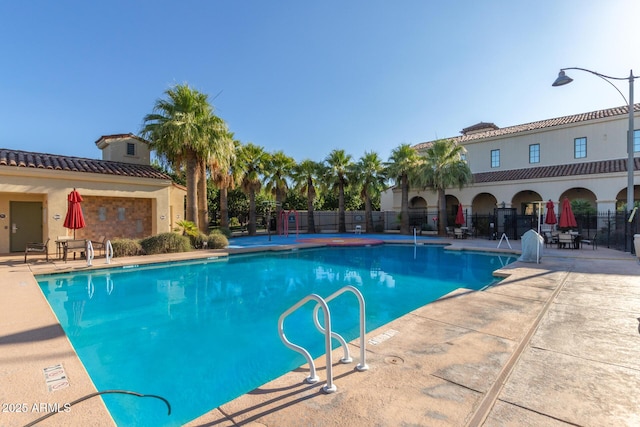 pool featuring fence and a patio