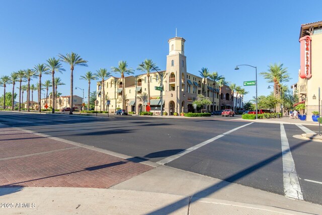 view of road featuring traffic signs, sidewalks, curbs, and street lights