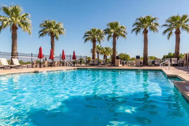 pool with a patio and fence