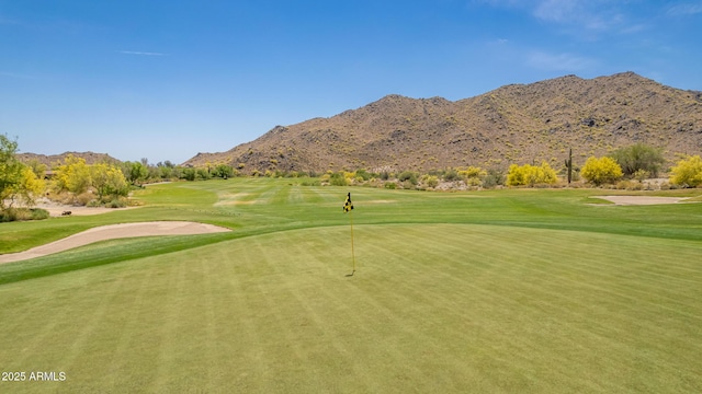 view of community with a yard, a mountain view, and golf course view