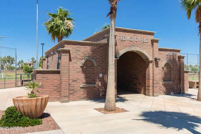 community sign featuring a gate and fence