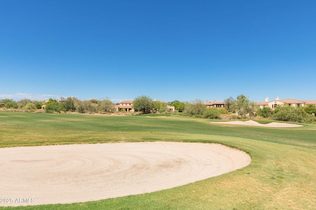 view of home's community with a lawn and view of golf course