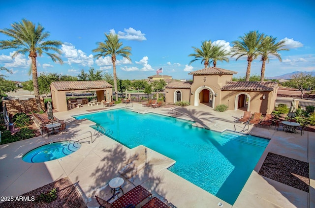 community pool with fence, a community hot tub, a patio, and a gazebo