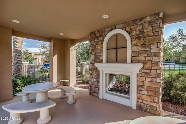 view of patio / terrace with fence and an outdoor stone fireplace