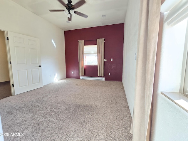 carpeted spare room with ceiling fan and a baseboard heating unit