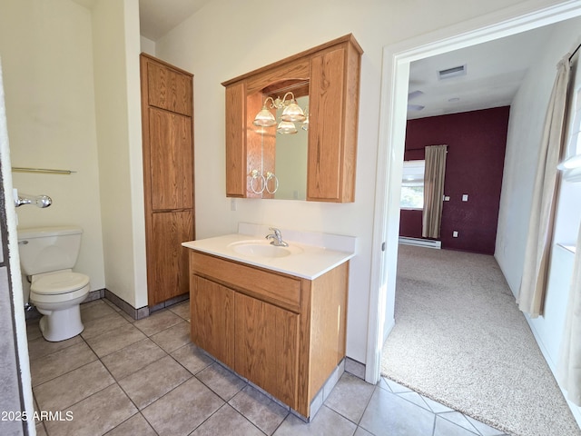 bathroom with toilet, vanity, a notable chandelier, and tile patterned flooring