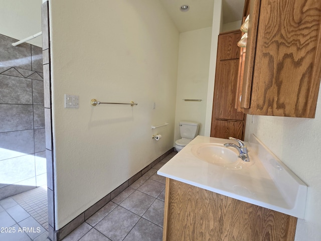 bathroom with toilet, tile patterned floors, and vanity