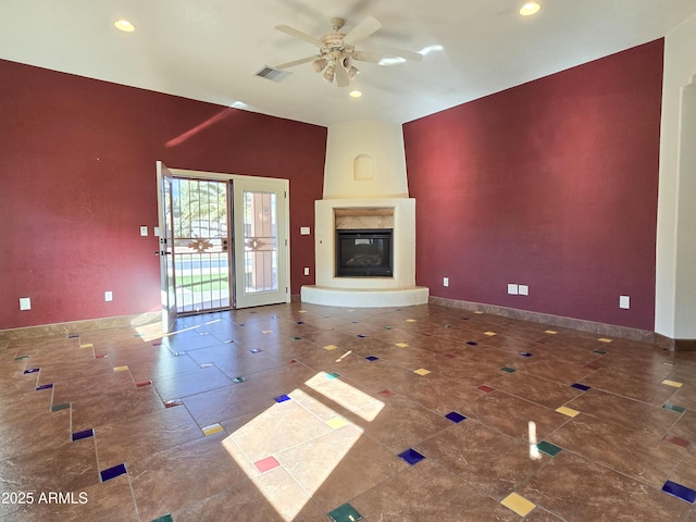 unfurnished living room with a premium fireplace and ceiling fan