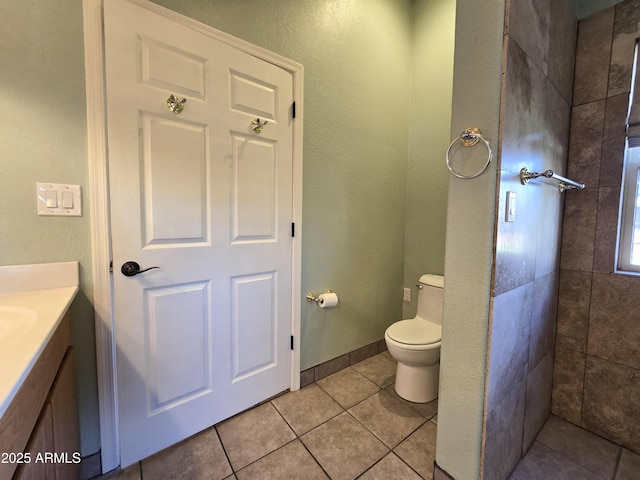 bathroom with toilet, vanity, and tile patterned flooring