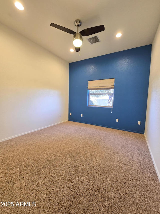 empty room featuring ceiling fan and carpet