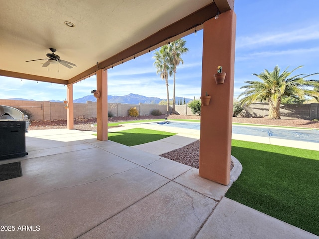 view of patio / terrace featuring ceiling fan and a mountain view