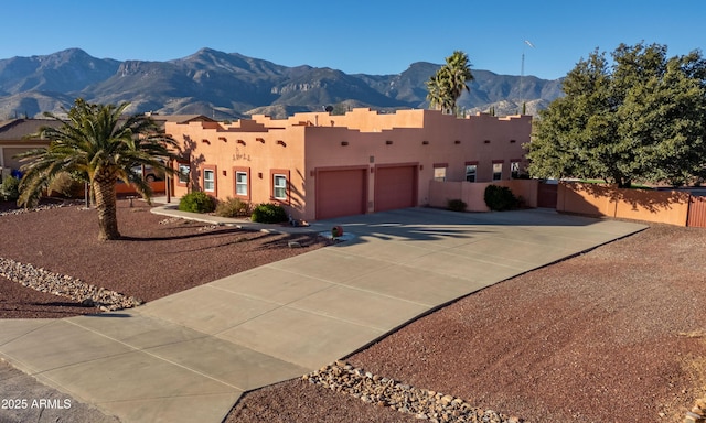 pueblo revival-style home with a mountain view and a garage